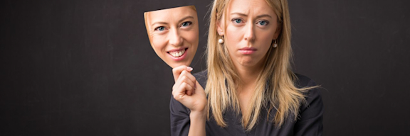 Darstellung von Depression: Traurige Frau hat eine glückliche Maske.