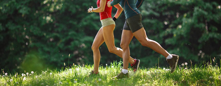 Junges paar joggt im Frühling in der Natur.