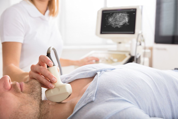Ärztin macht Ultraschall der Schilddrüse beim Patienten