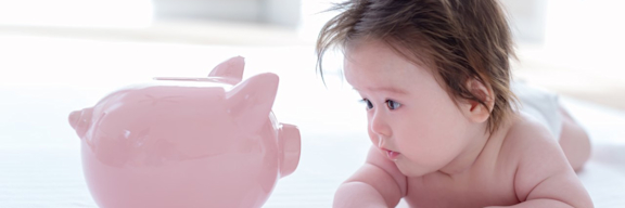 Es ist ein Baby mit einem Sparschwein zu sehen.