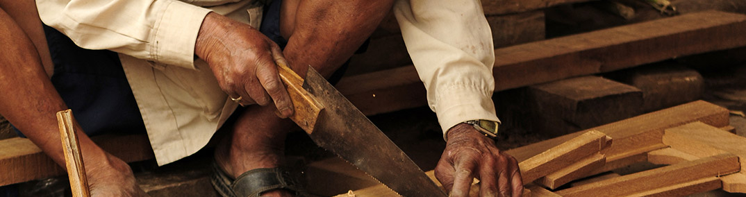 Homem cortando madeira com serrote