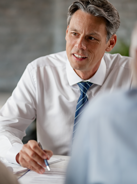 Male financials advisor engaging in a conversation with clients. 