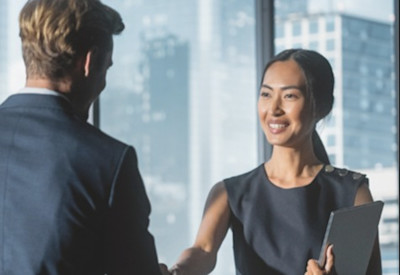 young woman advisor shakes hands with her mentor after agreeing on a development path
