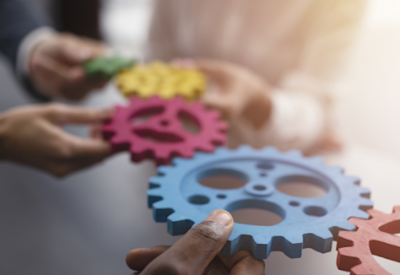 hands holding gears representing trends in M&A