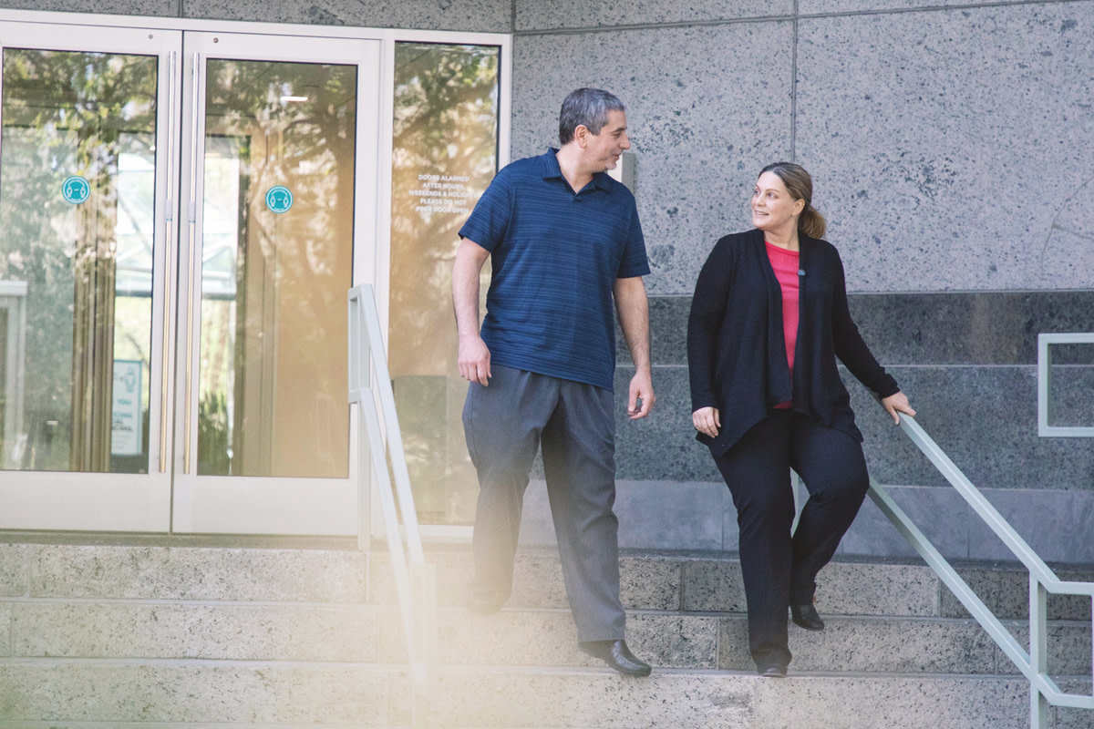 Two colleagues walking together outside of a building