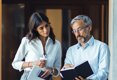 a businesswoman and businessman review a document