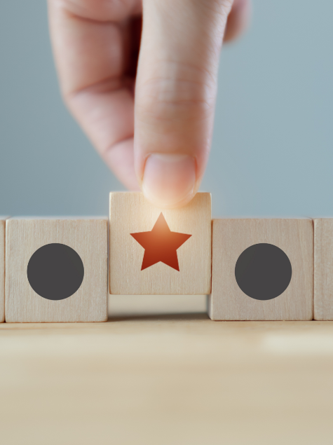 Hand pulling a star out from building blocks for outsourcing