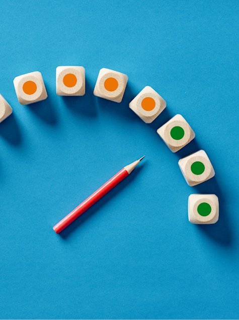 Pencil and blocks showing progression from orange to green, insinuating positive change