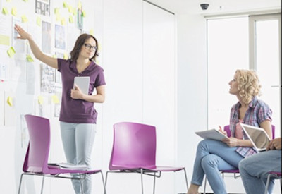 a woman presenting strategies on a white board