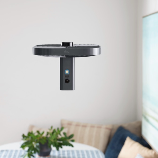 Always Home Cam hovering in a room above a white furniture piece