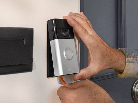 A Ring doorbell being changed against a white wall.
