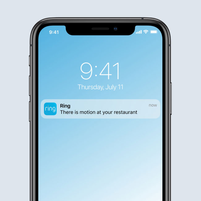 Smartphone screen showing a Ring App notification that reads 'There is motion at your restaurant,' with a timestamp of 9:41 AM on July 11.