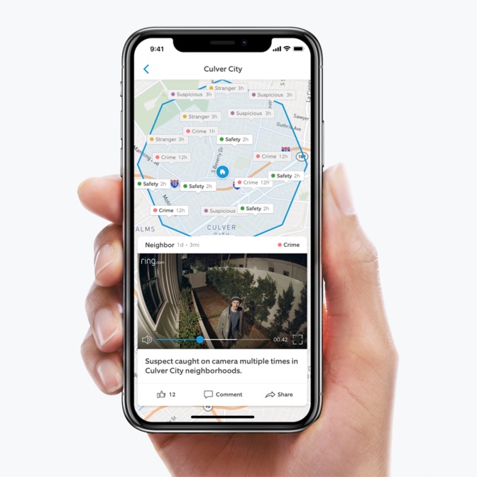 Hand holding an iPhone, and on the screen is the Neighbors app user interface. The UI includes a neighborhood map and a Ring home video.