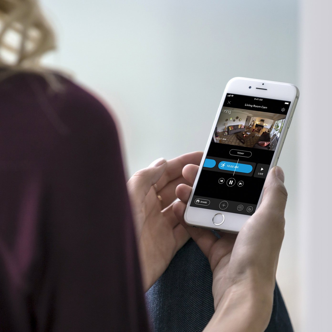 Person holding phone with Ring app video recording view