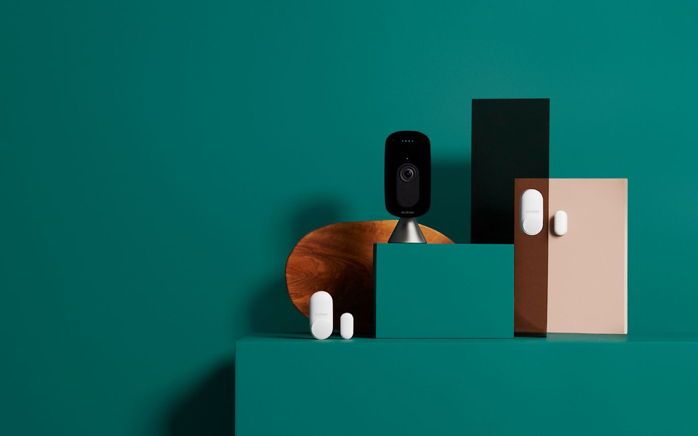 The ecobee Essential Home Security Solution on a green background.