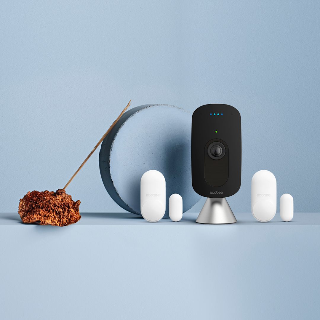 ecobee SmartCamera and 2 ecobee SmartSensors for doors & windows on a blue background.