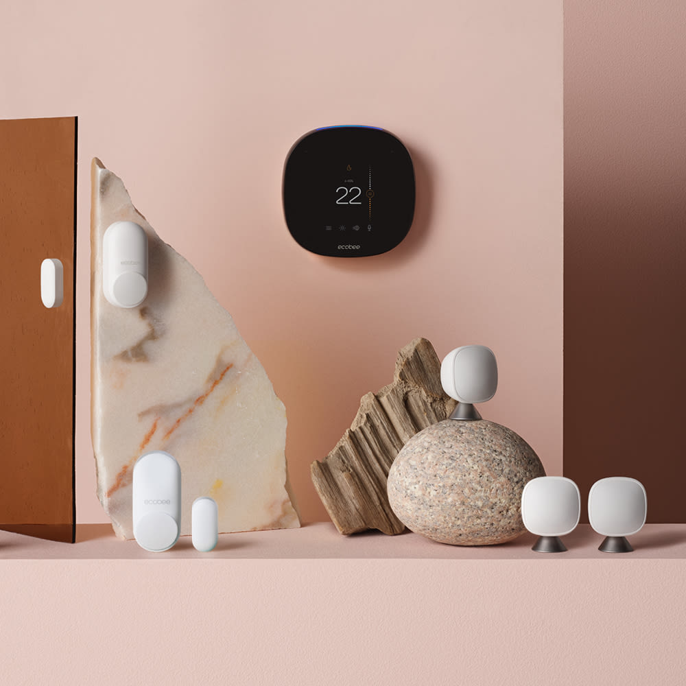 SmartThermostat with voice control, SmartCamera with voice control, 3 SmartSensors, and 2 SmartSensors for doors & windows floating on a blue background.