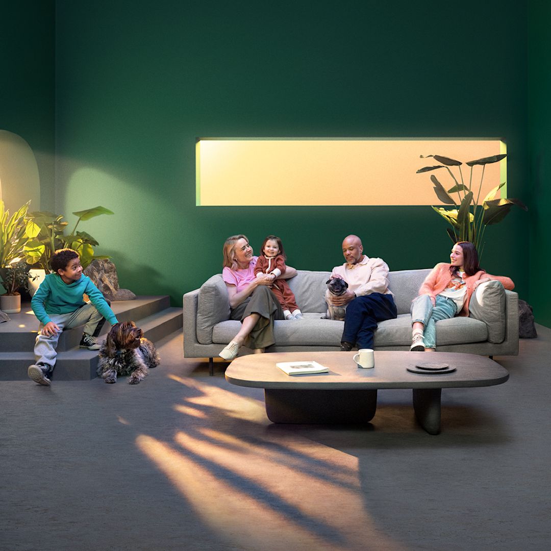 A family sits in a living room with natural light.