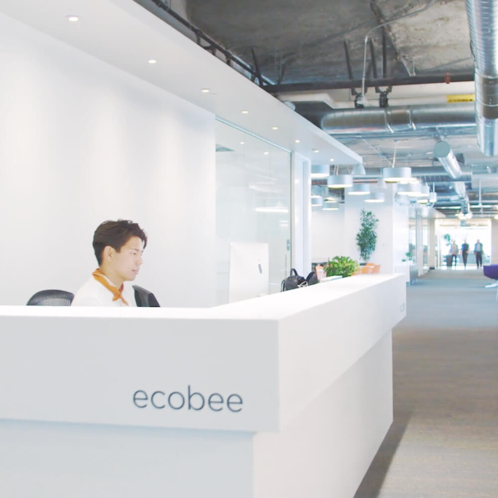 Man sitting behind welcome desk at ecobee headquarters.