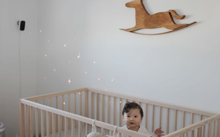 A happy baby in a crib.