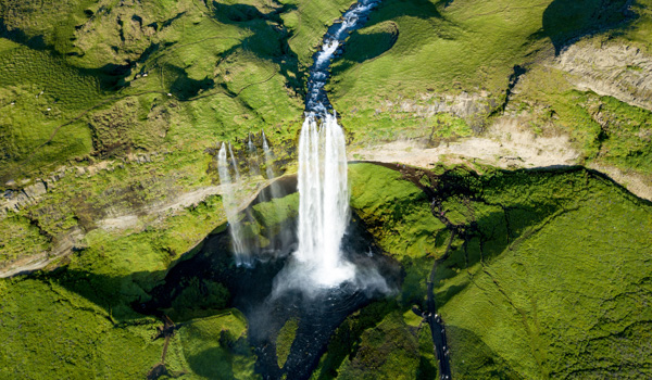 Aerial view of Seljalandsfoss waterfall in a lush green landscape..