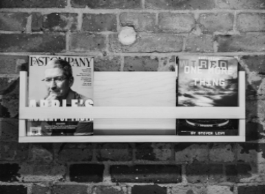Magazines placed on a wooden shelf