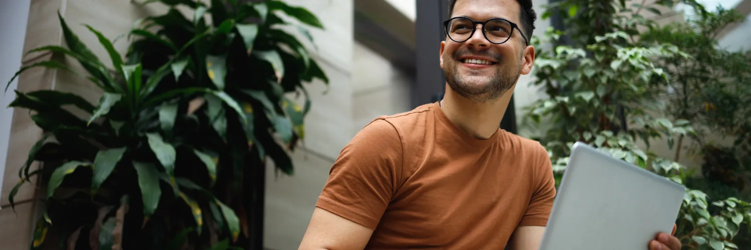 A business owner smiling, using MYOB automated banking tools to streamline financial management and reporting.