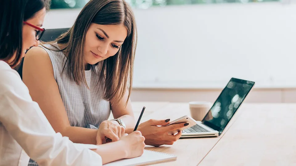 Two female colleagues in an office working together.