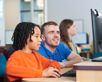 Tutor supporting a child in an Explore Learning centre