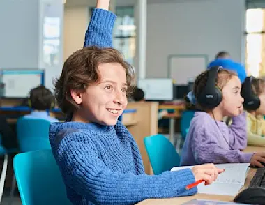 A child raising their hand to ask a question during their Explore Learning maths and English tuition session