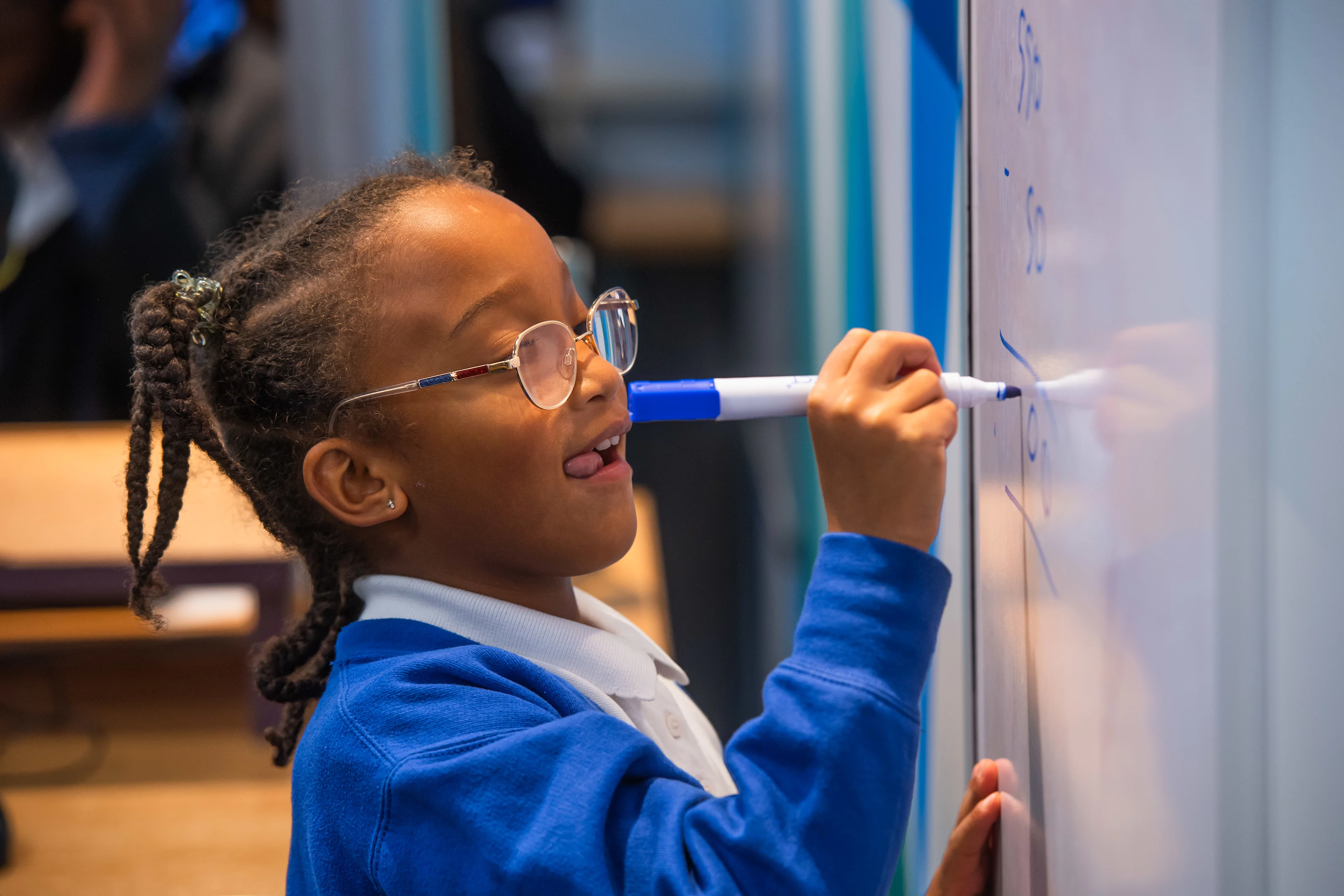 Child writing on the whiteboard in an Explore Learning tuition centre
