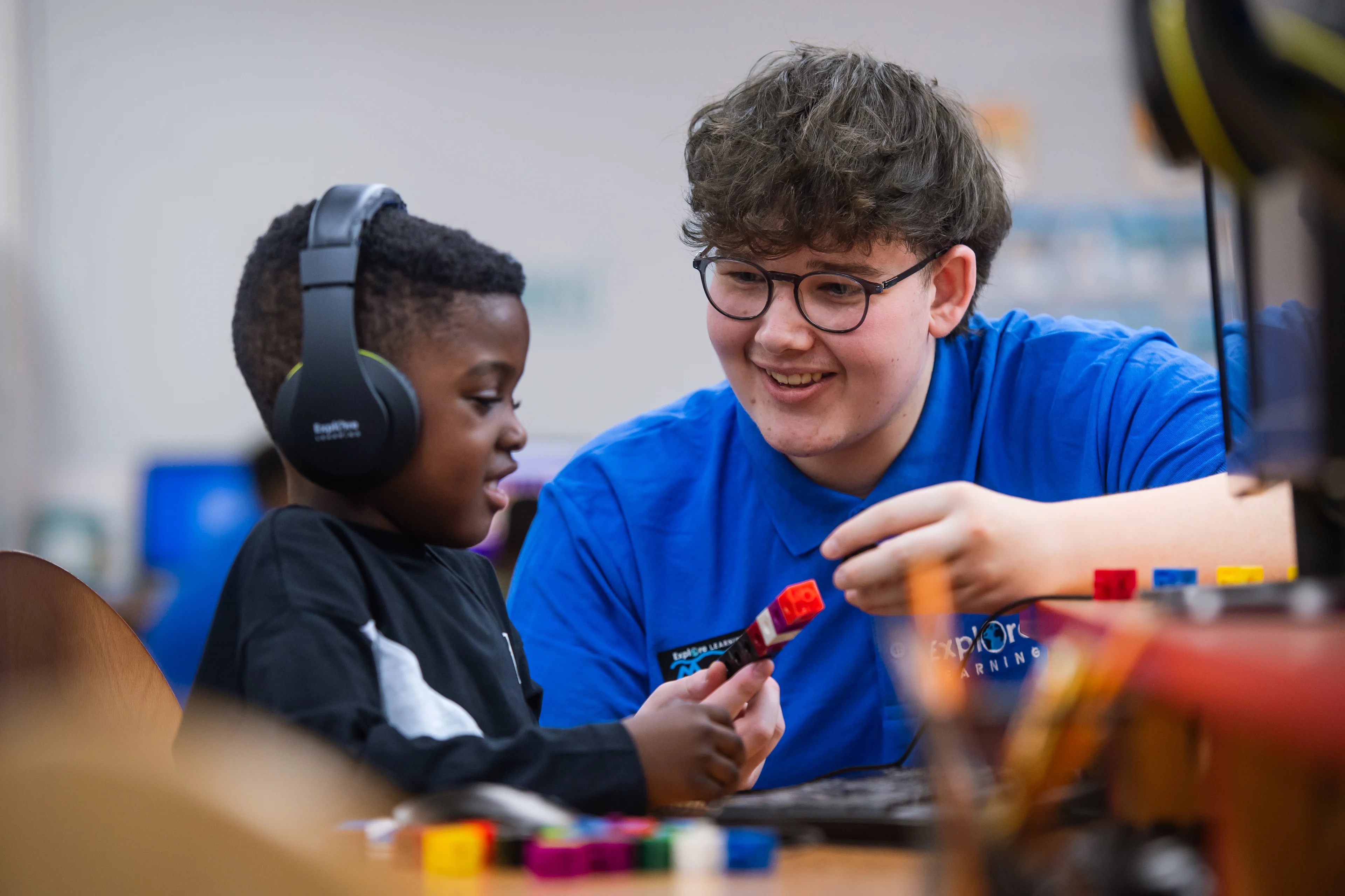 Tutor helping a child learn in an Explore Learning centre