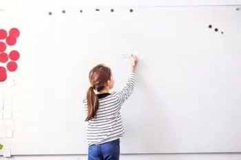 Child writing goals on a whiteboard