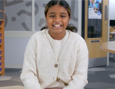 A young girl called Saniyah smiles in an Explore Learning centre.