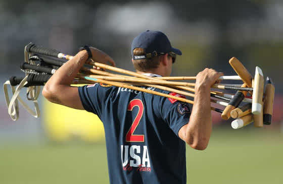 USA polo player holding several polo mallets
