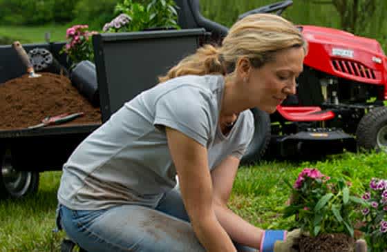 Woman gardening with tractor in background