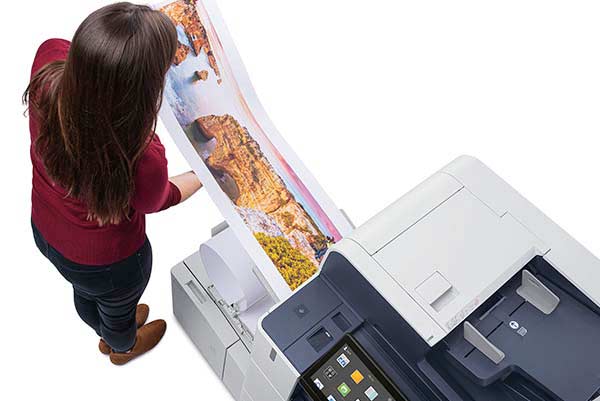 Woman looking at color pages printed on Xerox AltaLink C8100 Series