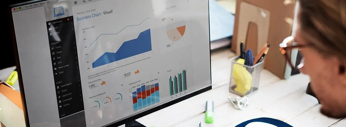 Man looking at graphs on screen