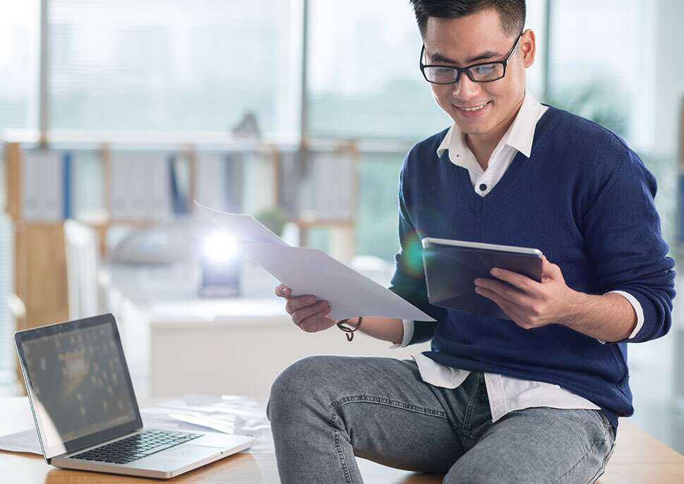 Happy man with tablet and laptop