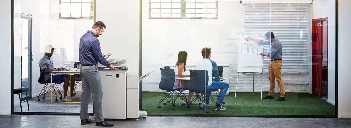 Man using Xerox Printer in busy office space