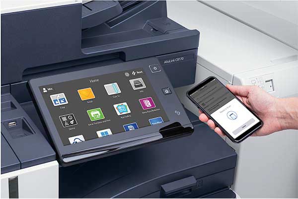 Hand holding a smartphone near an Xerox AltaLink 8100 Series MFP