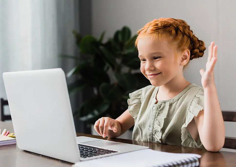 Happy young girl working on a laptop