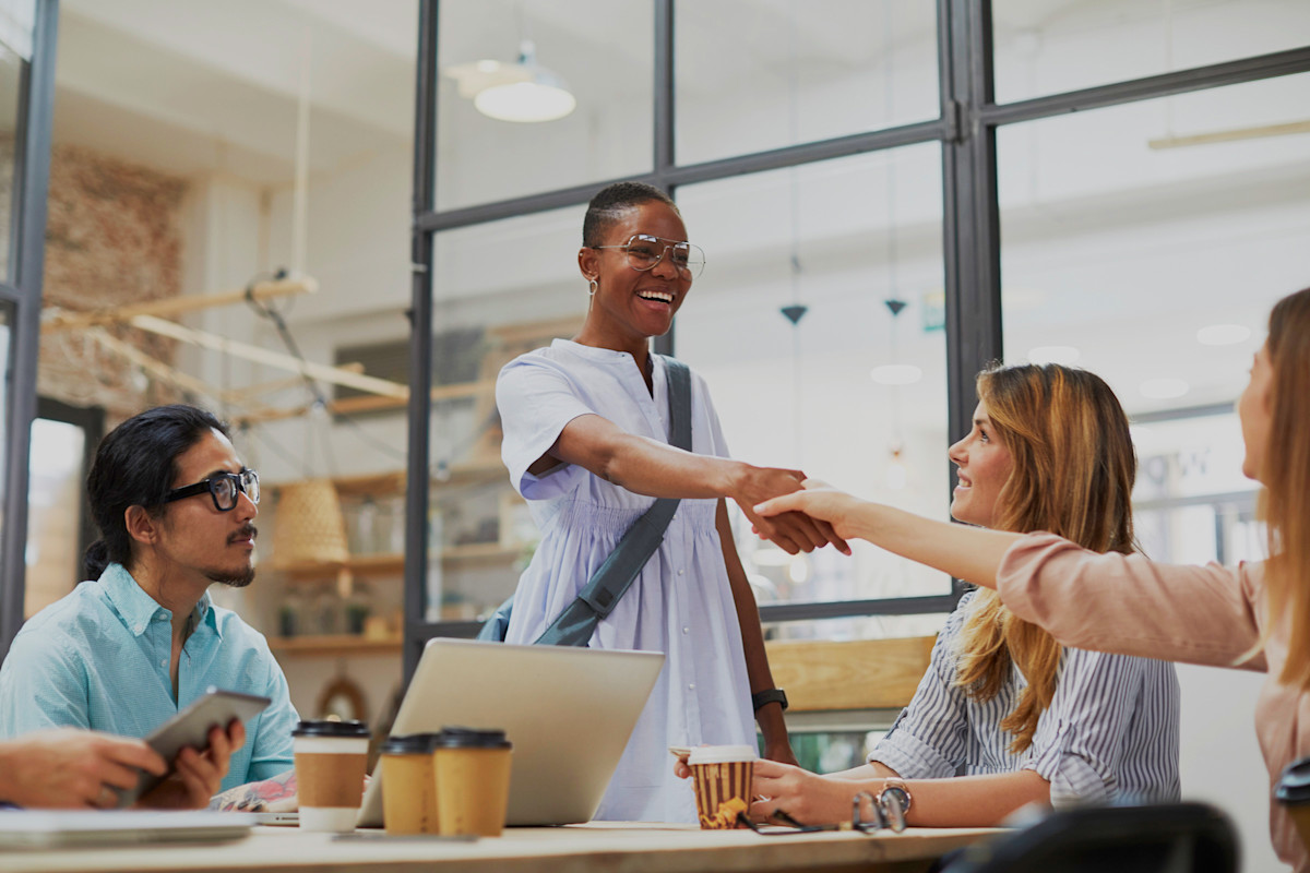 People in conference room - woman shaking hands