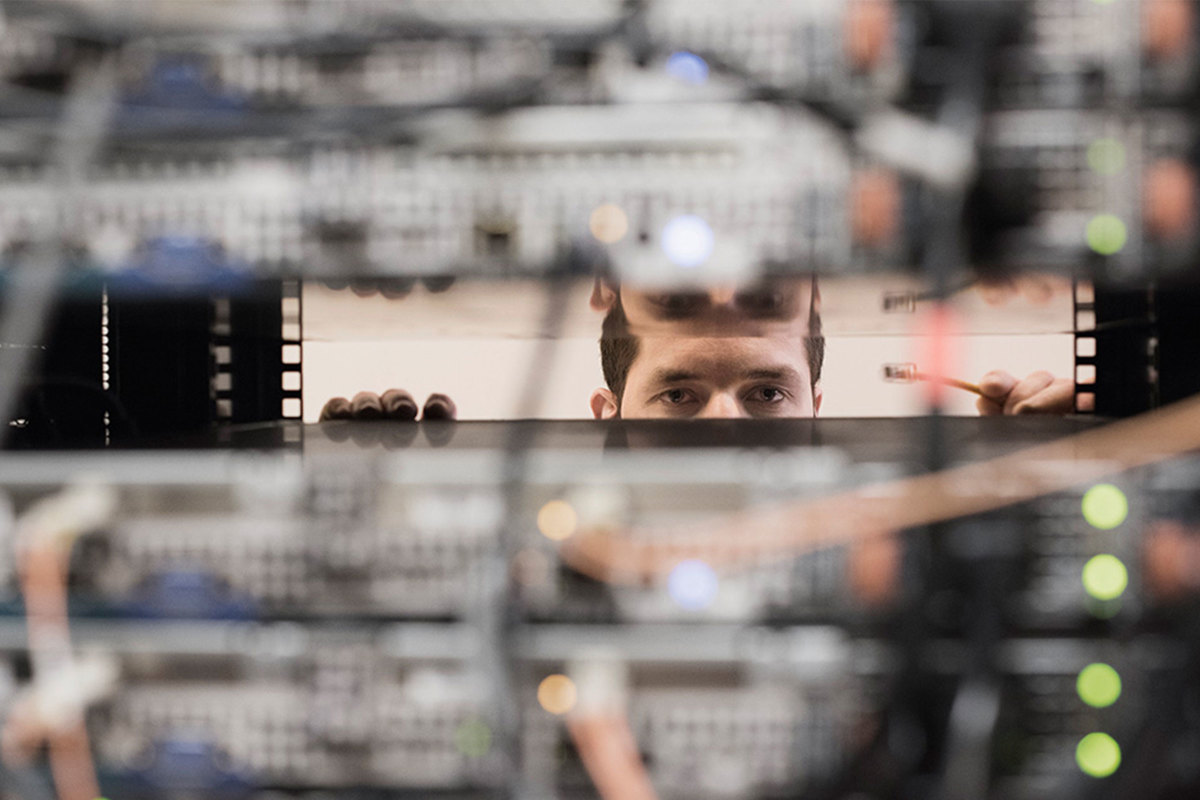 Man looking between stacked servers