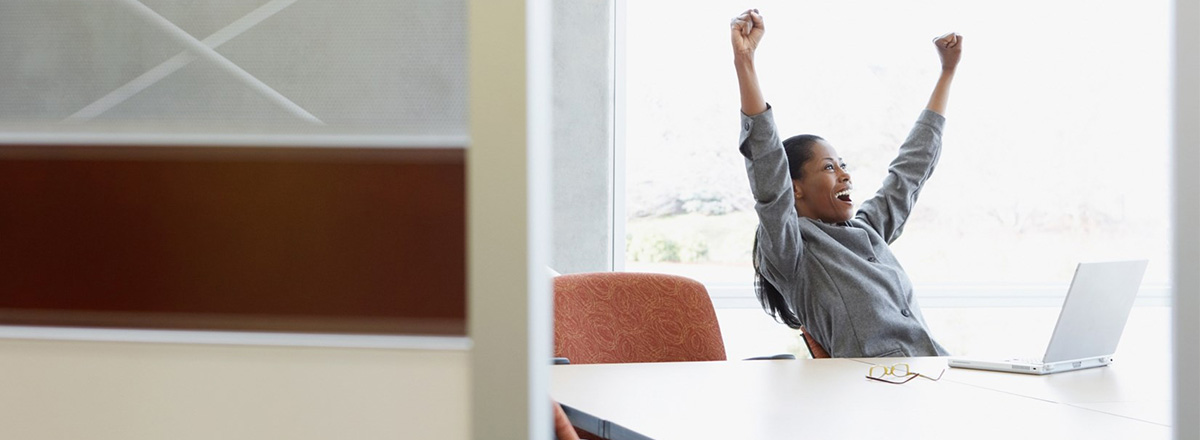 woman at desk punching air