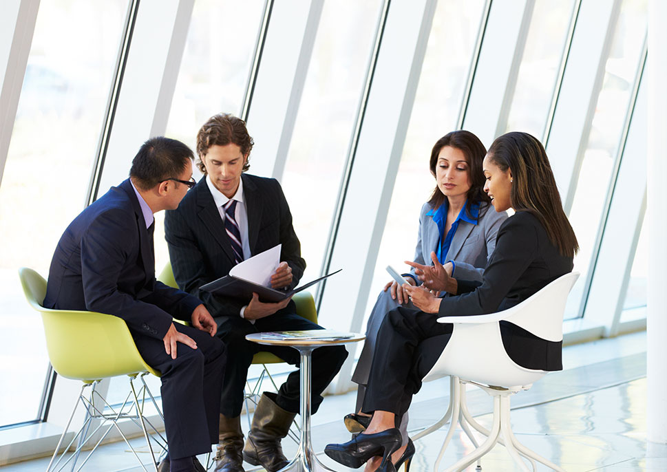 Diverse colleagues meeting in front of large windows