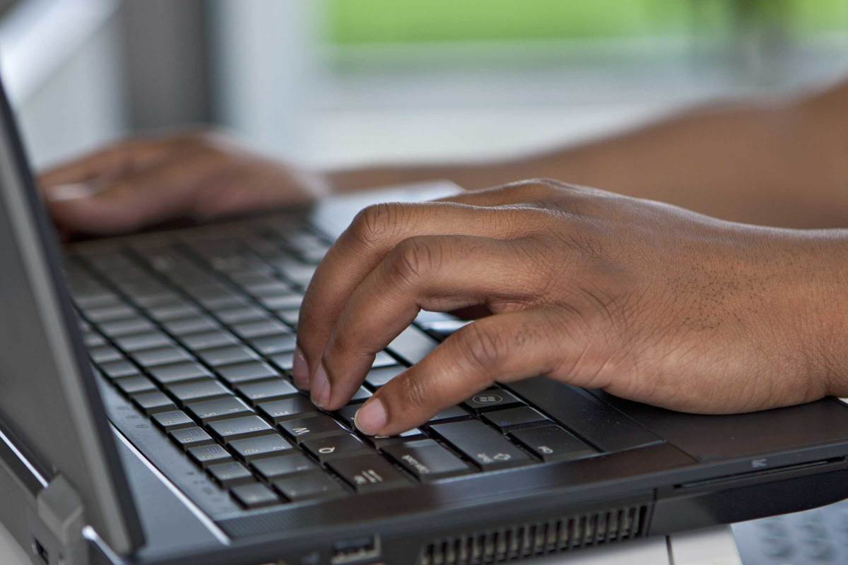 Hands typing on laptop keyboard