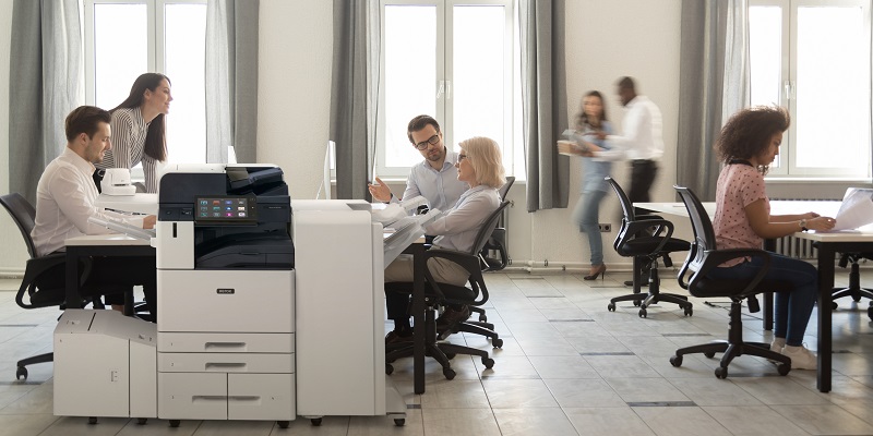 Colleagues meeting next to a Xerox AltaLink B8200 Series MFP