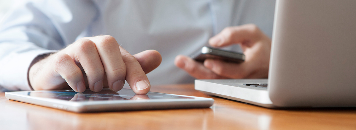 Person using a tablet, smartphone and laptop