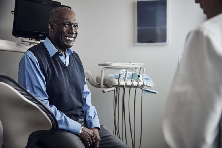 Happy elderly man sitting in an examination room waiting for dentist